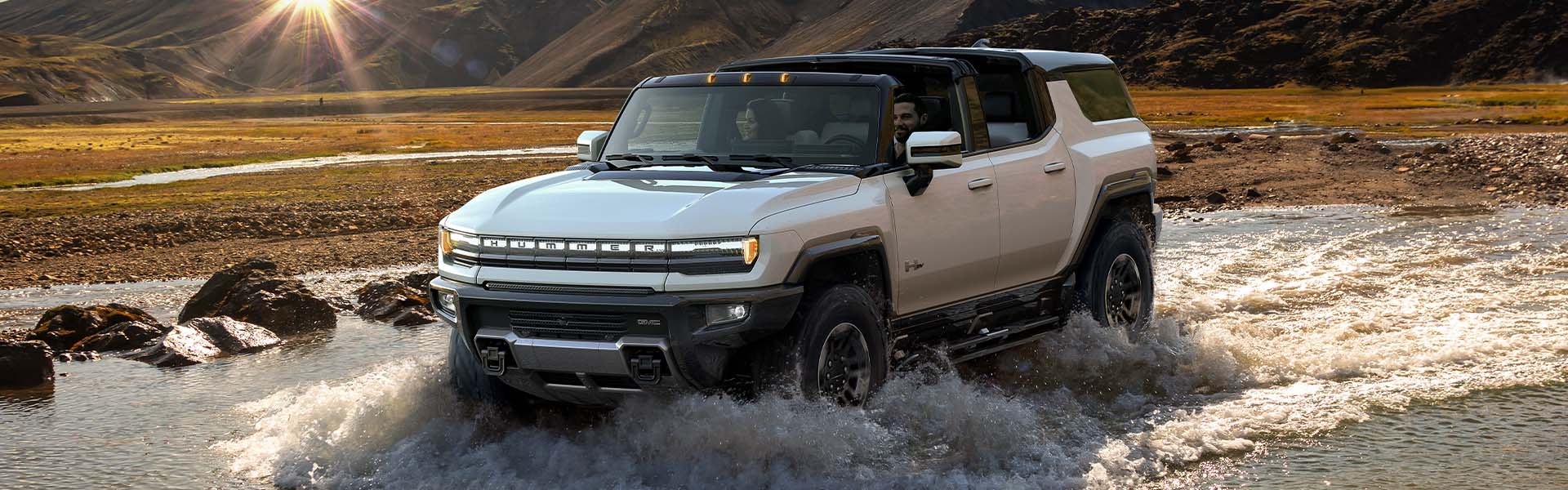 2024 GMC Hummer EV Pickup driving over stream