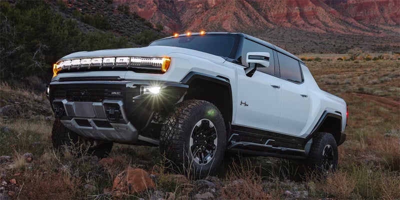 2024 GMC Hummer EV Pickup driving over rocks