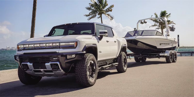 2024 GMC Hummer EV Pickup towing a boat